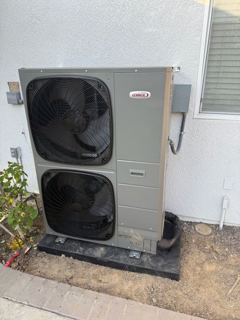 Lennox air conditioning unit installed outside a house on a concrete base.